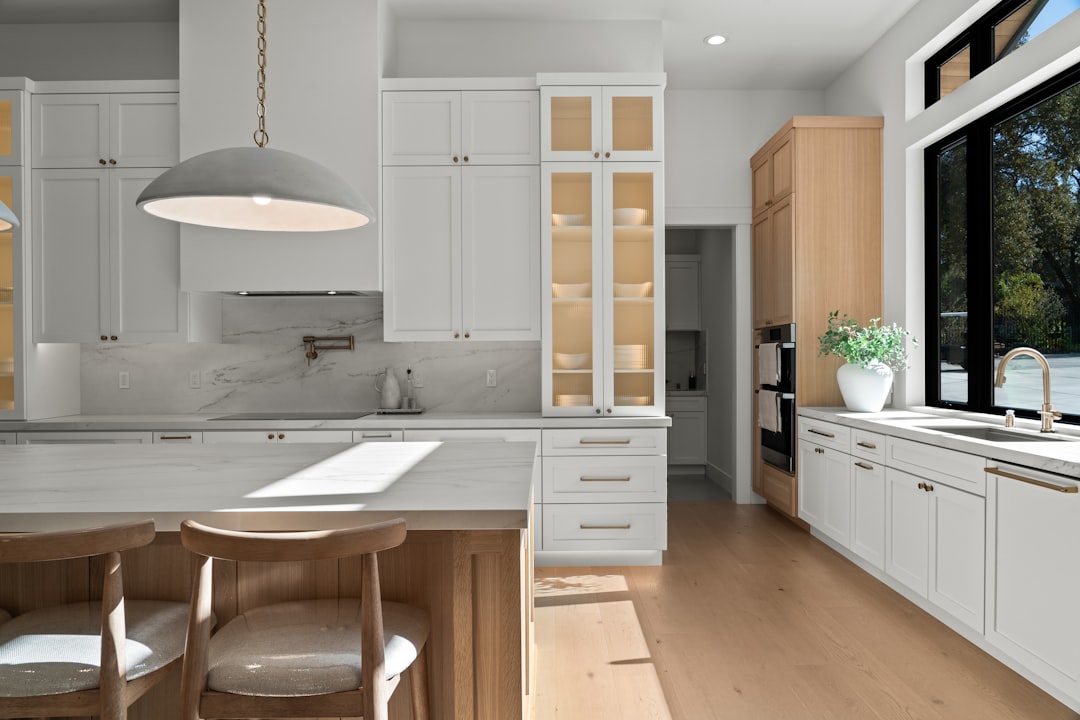 Warm wood, pale cabinetry and natural light in a calm kitchen interior